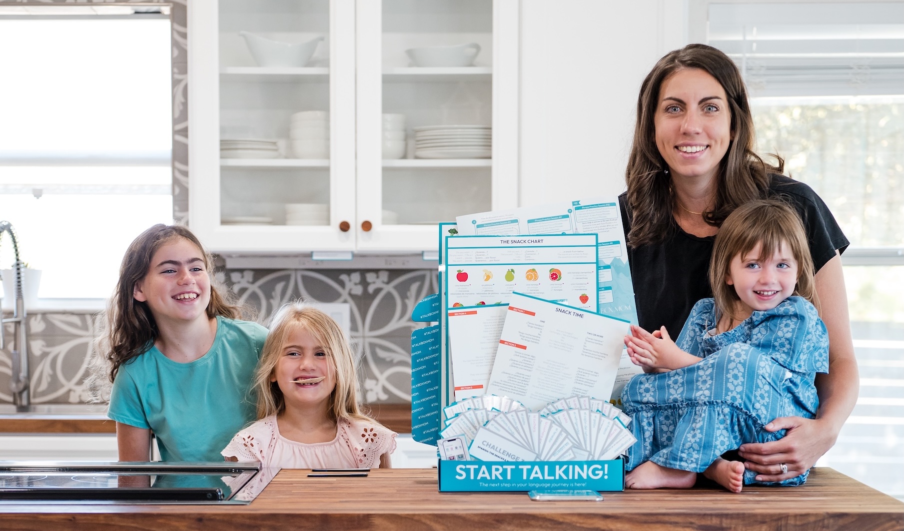 Fluency Family smiling with their Snacks and Kitchen Box